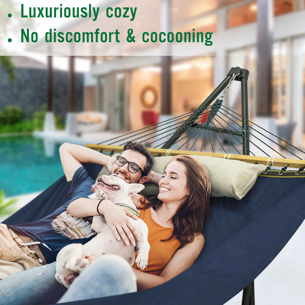 Dark blue hammock with black stand and multicolor rope, loaded with pillows