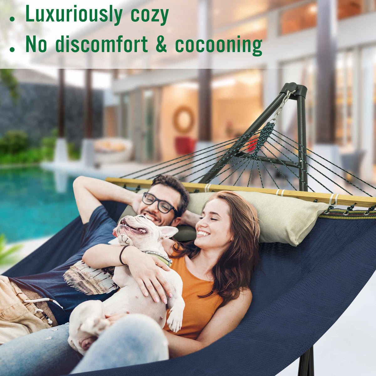 Dark blue hammock with black stand and multicolor rope, loaded with pillows