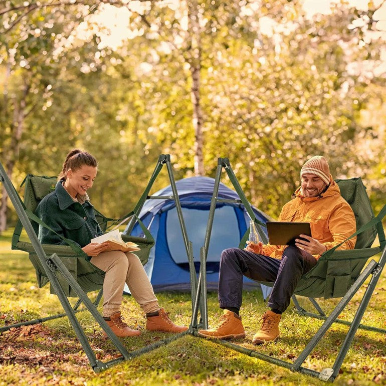 Two green hammock chairs on metal stands outdoors, with two seated people