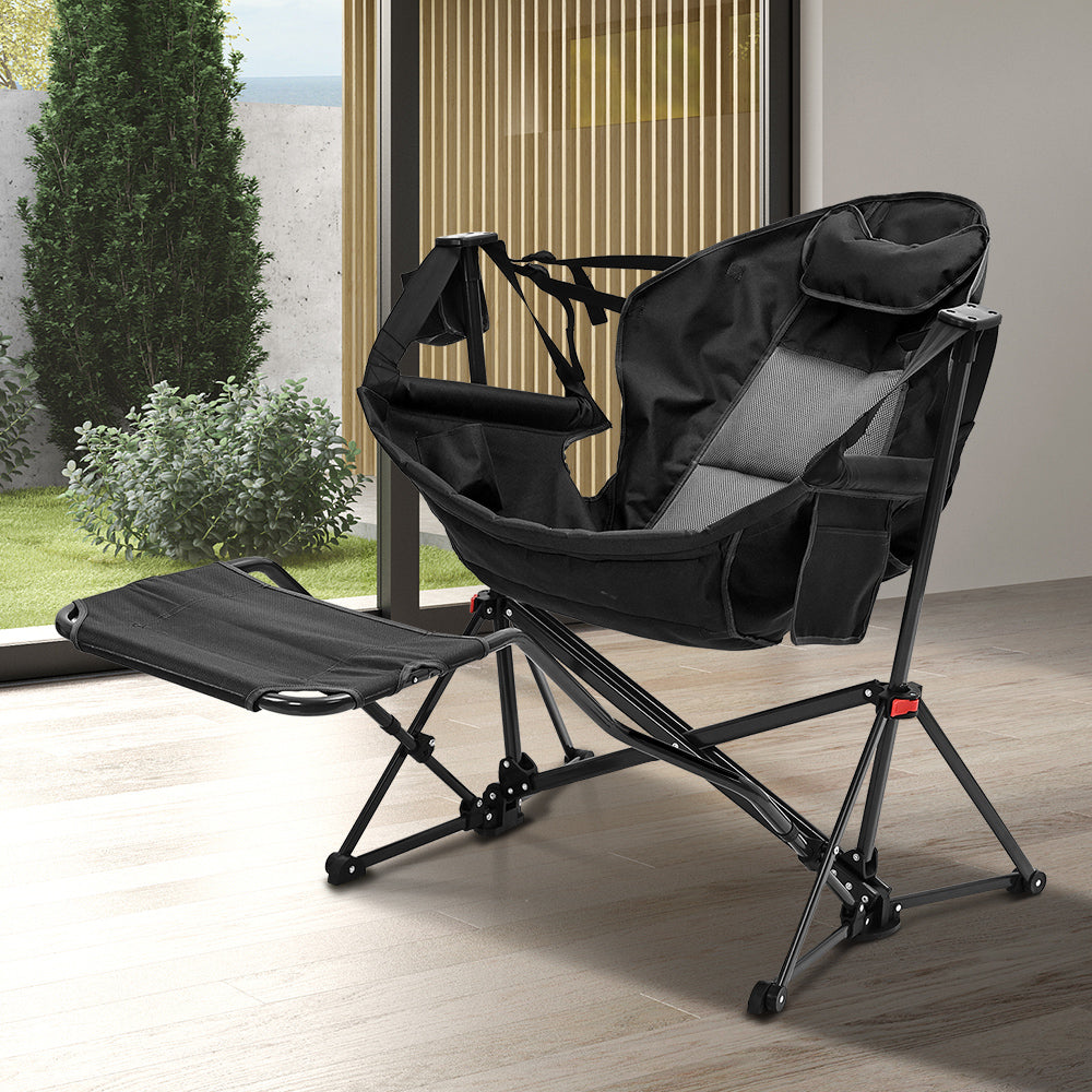 Black foldable camping rocking chair with footrest on outdoor patio