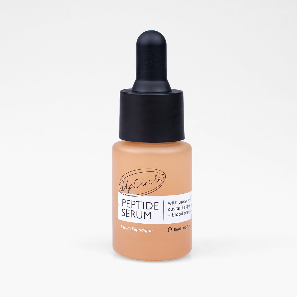 Travel-size peptide serum bottle with black dropper and peach serum