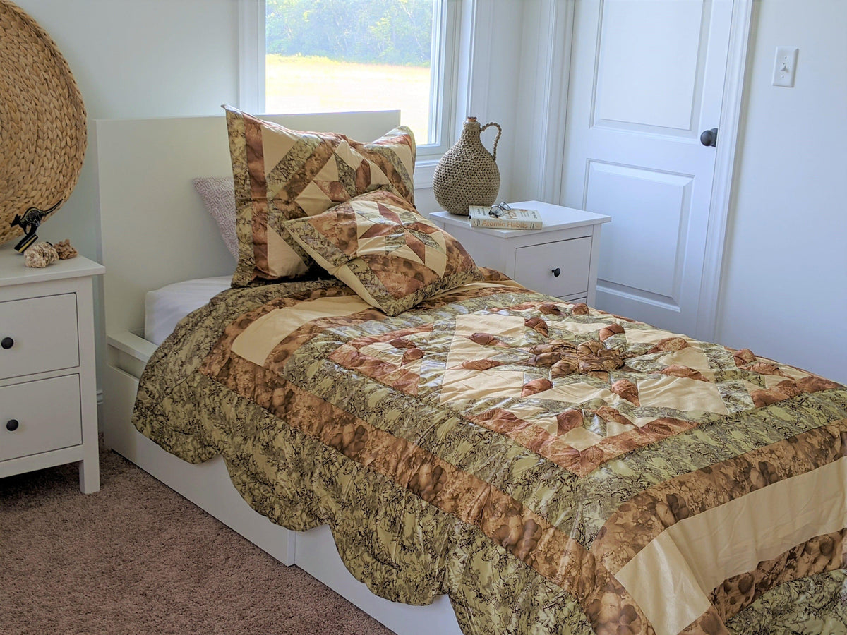 Earthy-toned comforter set with patchwork pattern and two coordinating decorative pillows
