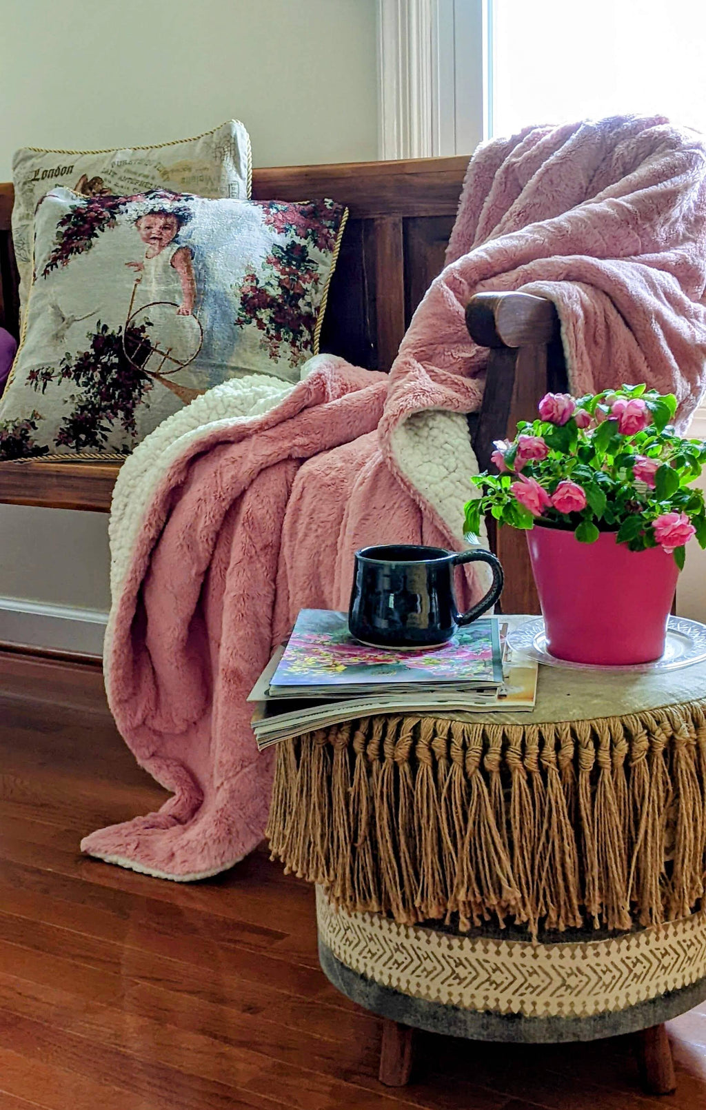 Dusty pink faux fur throw blanket draped over furniture with white reverse edge