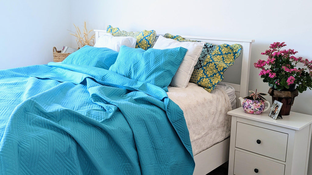 Turquoise teal quilted bedspread with wave pattern and coordinated decorative pillows