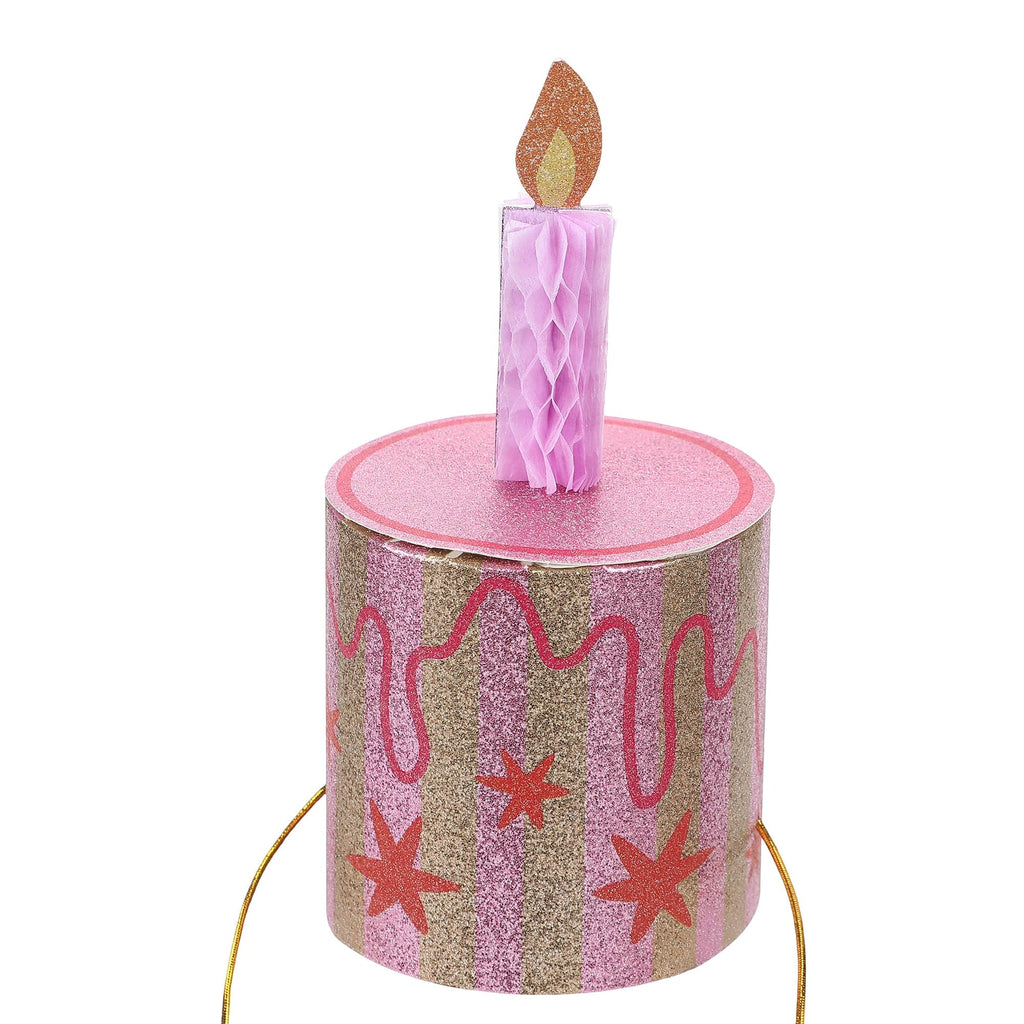 Pink glitter cake party hat with orange candle and long gold tie cords