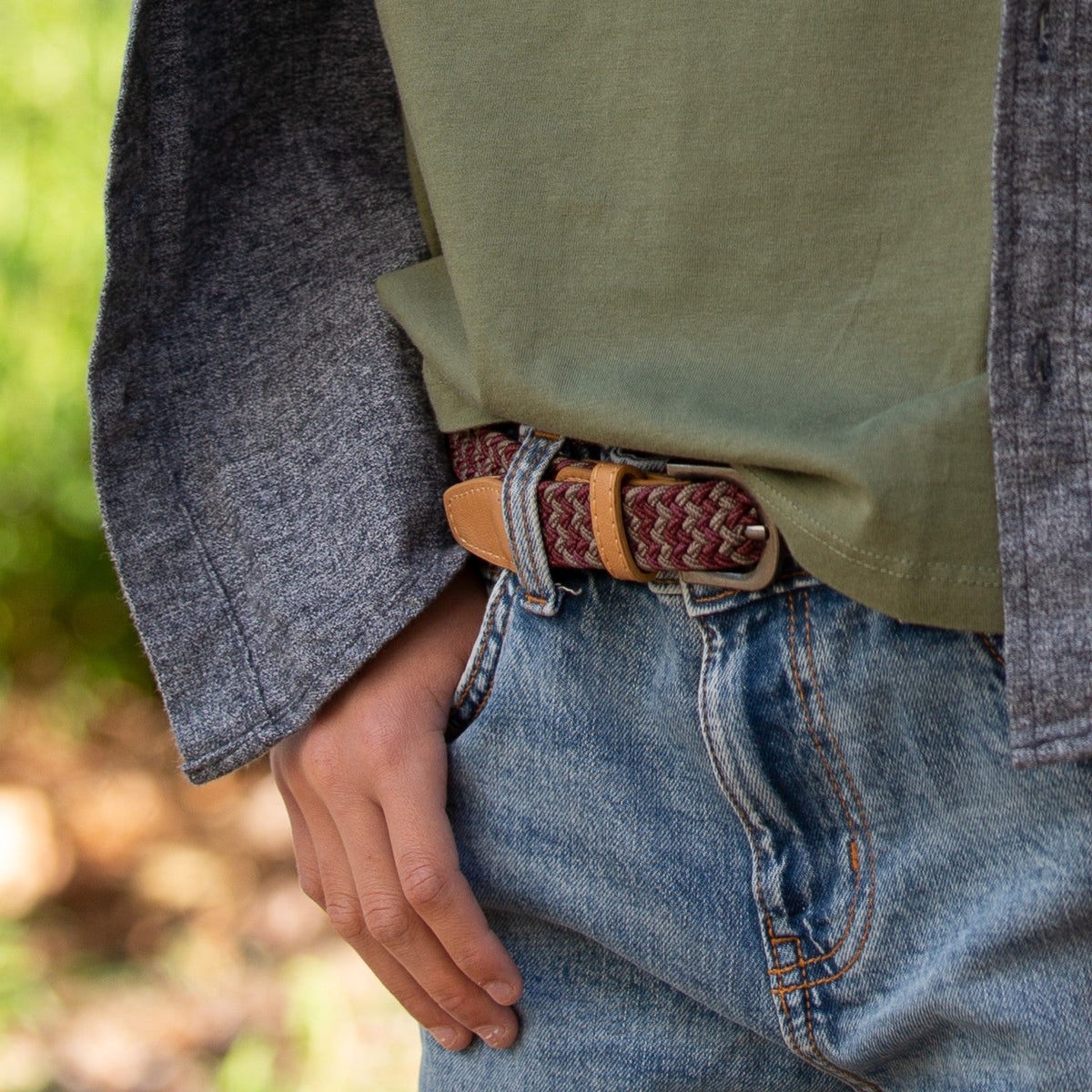 Braided kids belt on jeans, tan leather keeper with orange-brown weave and silver buckle