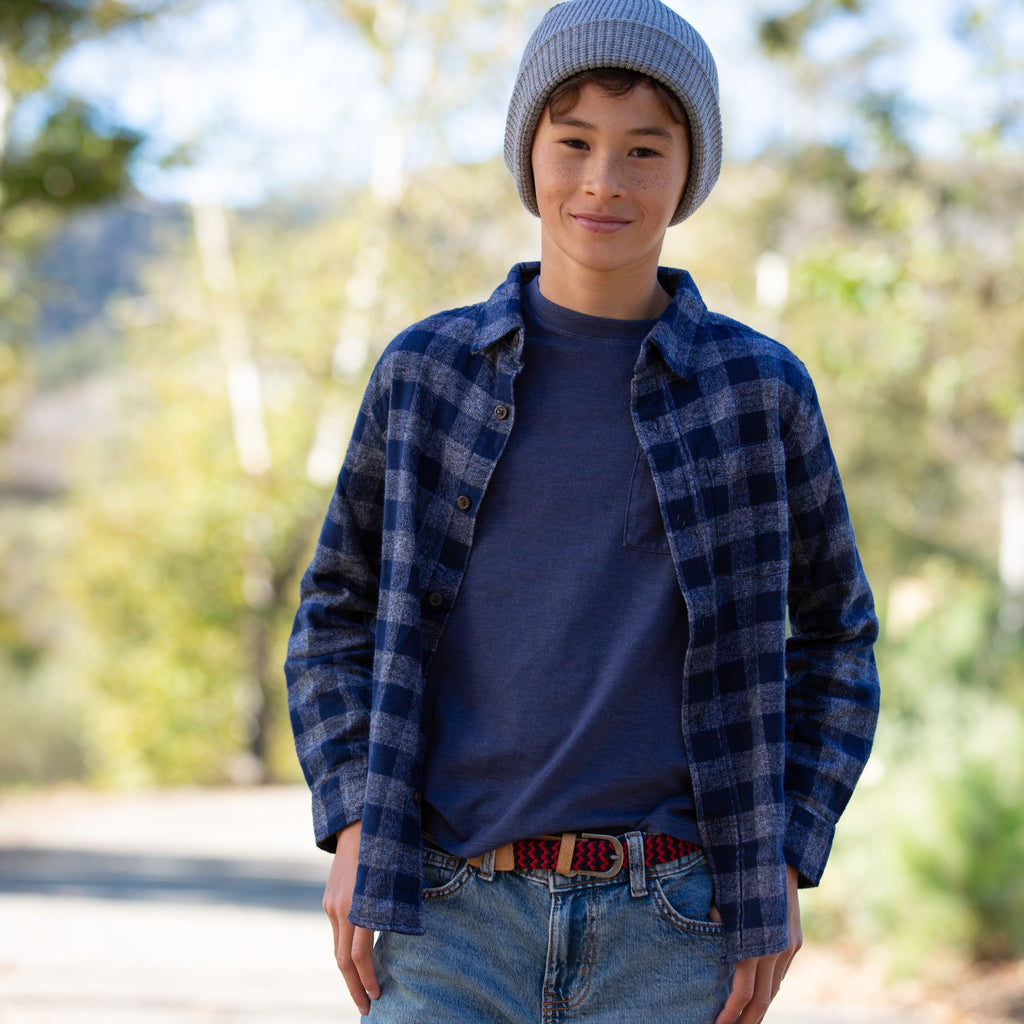 Stretchy leather belt for boys, red-blue woven strap with metal buckle on denim.