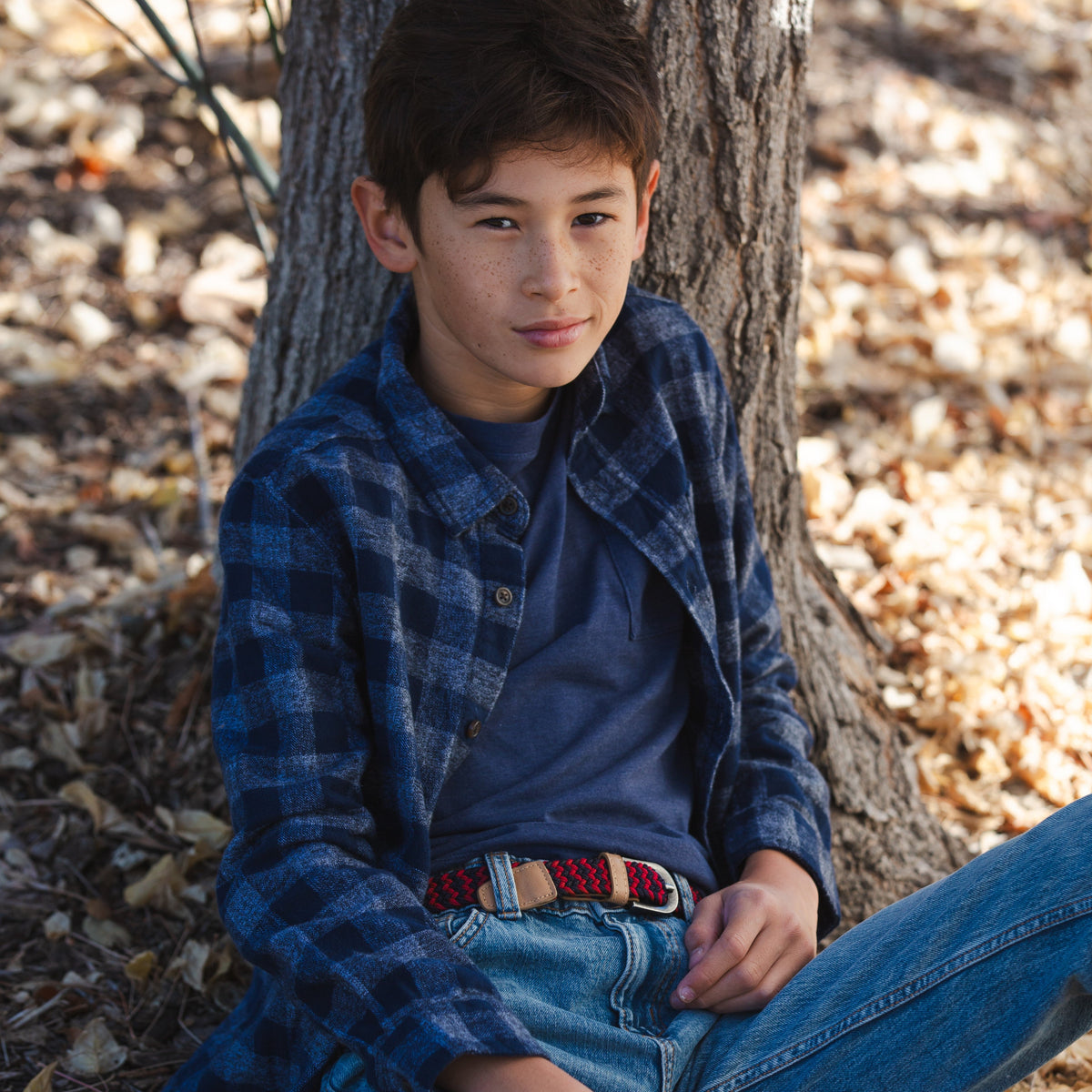 Kids woven belt on jeans, dark blue and red braid with tan leather buckle strap