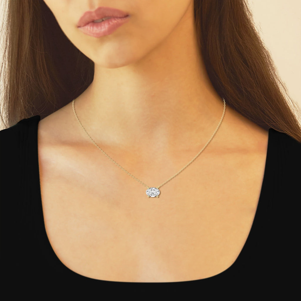 Oval lab-grown diamond solitaire necklace on delicate chain, worn close-up on neck