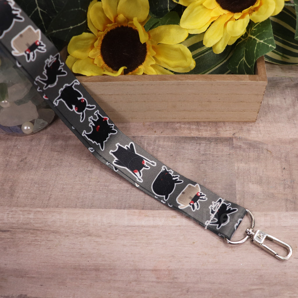 Black pet lanyard with white mothman-style graphics and silver clasp