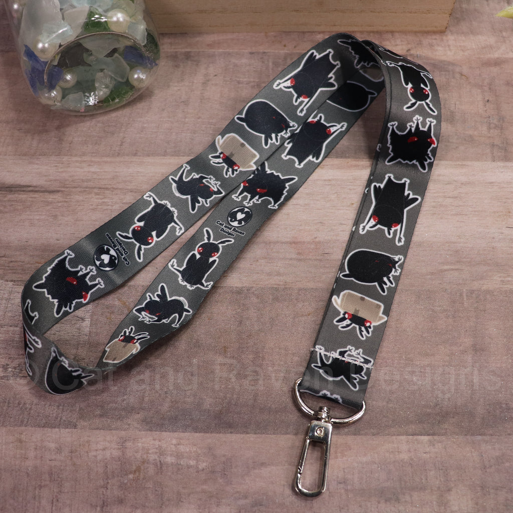 Black pet lanyard with white mothman-style graphics and metal clip