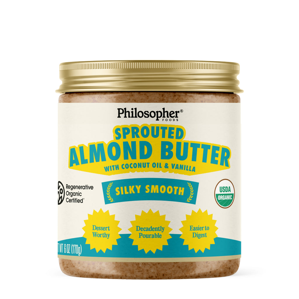 Sprouted almond butter jar with coconut oil and vanilla, gold lid, front label by Philosopher