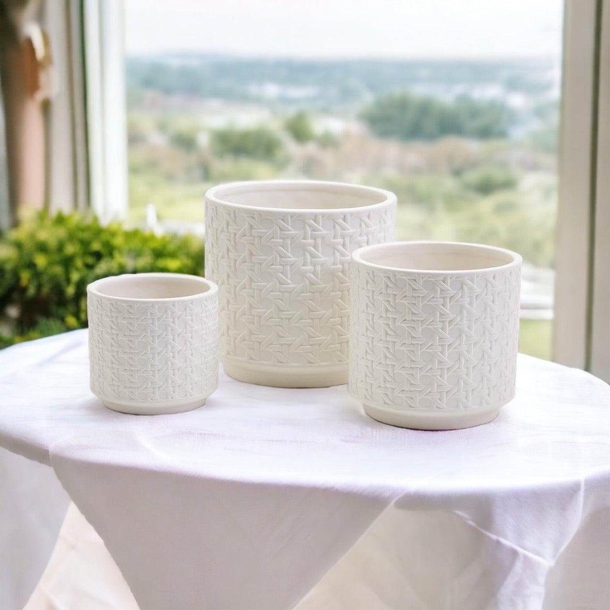 Three white textured cylindrical vases with web pattern, open tops visible