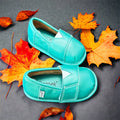 Teal slip-on barefoot shoe topper with stitching detail, shown with two shoes