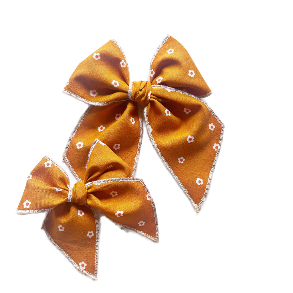 Caramel orange fabric bow set with white flower pattern and stitched edges