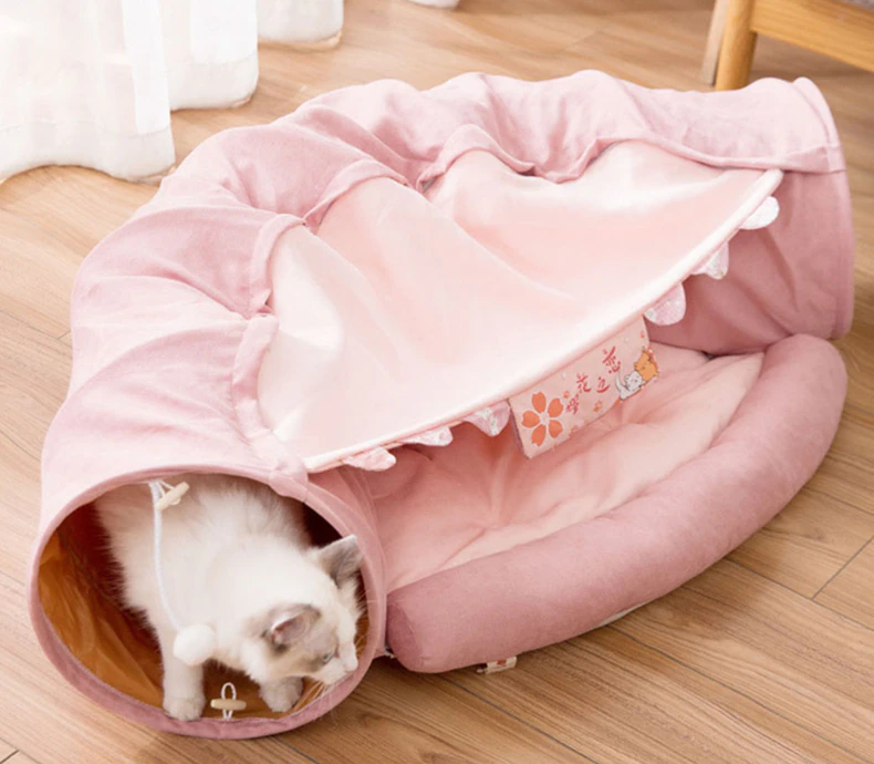 Collapsible cat tunnel tube with removable cat bed, light pink and beige, cat at open end