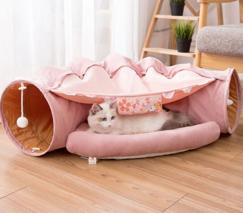 Collapsible cat tunnel tube with removable cushion, pink fabric, cat resting inside