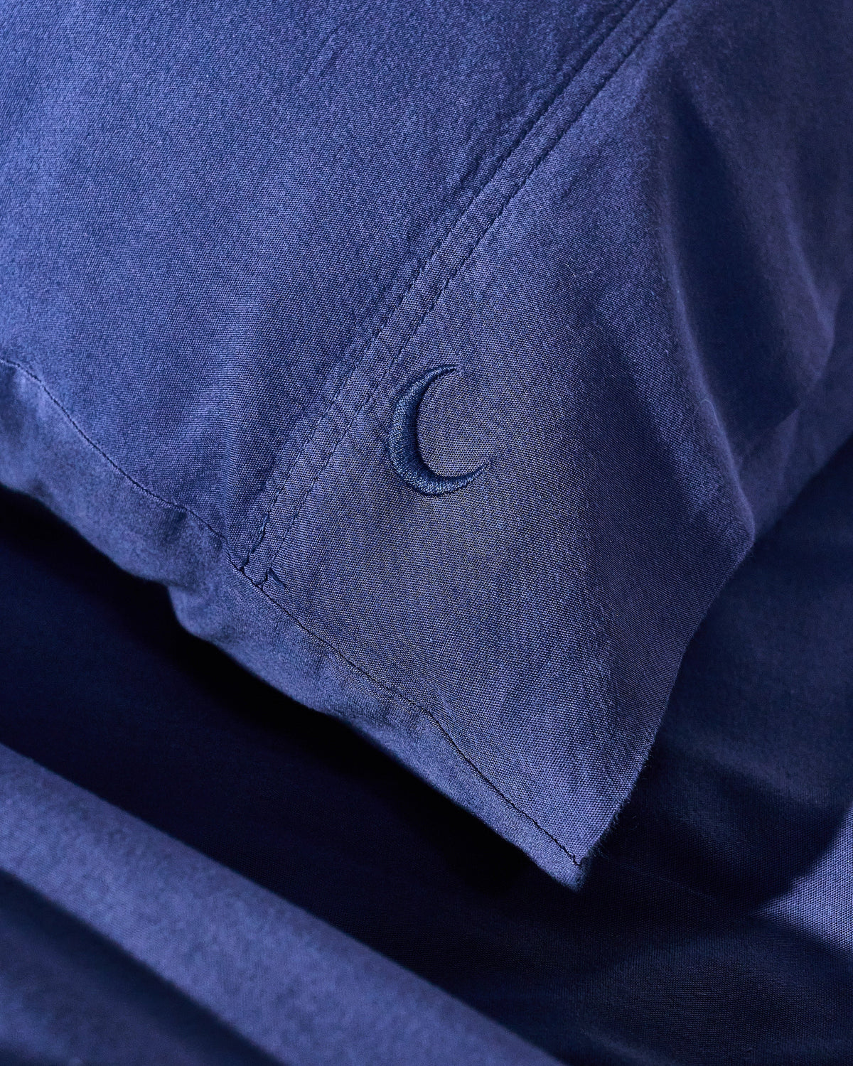 Milk fibre pillowcase set in dark blue with embroidered logo stitch detail