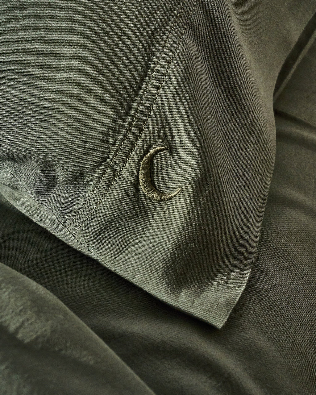 Highlands green pillowcase set close-up of fabric and embroidered C corner