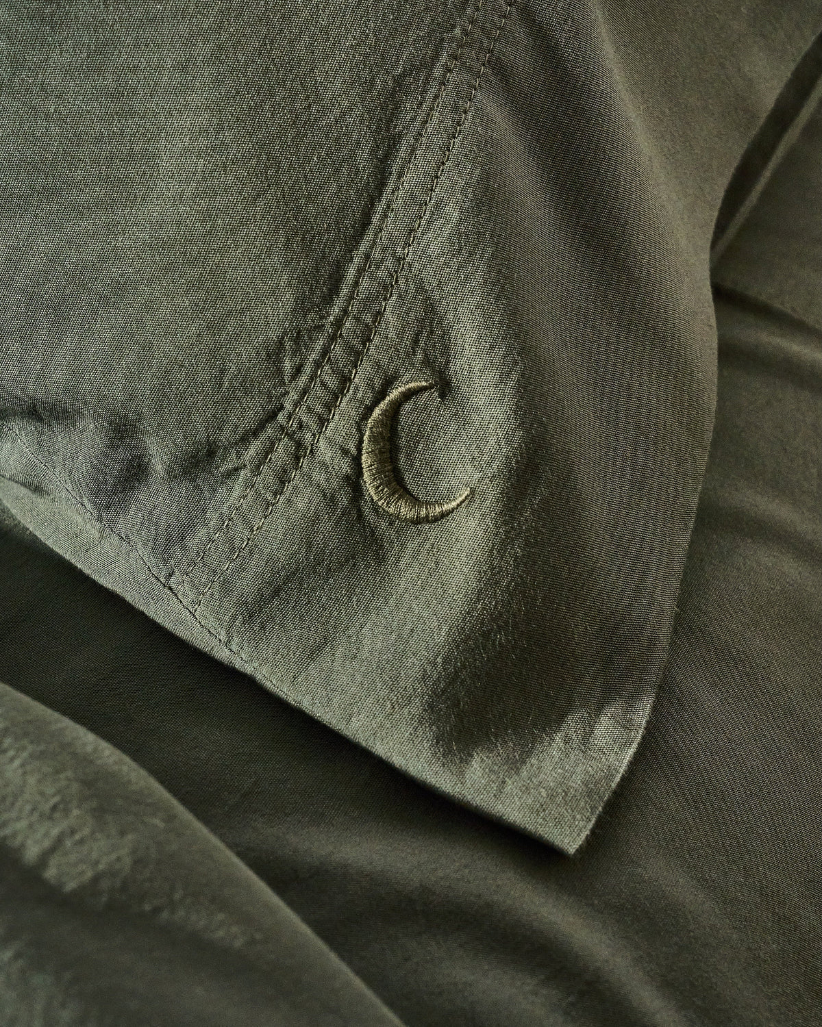 Highlands green pillowcase set close-up of fabric and embroidered C corner