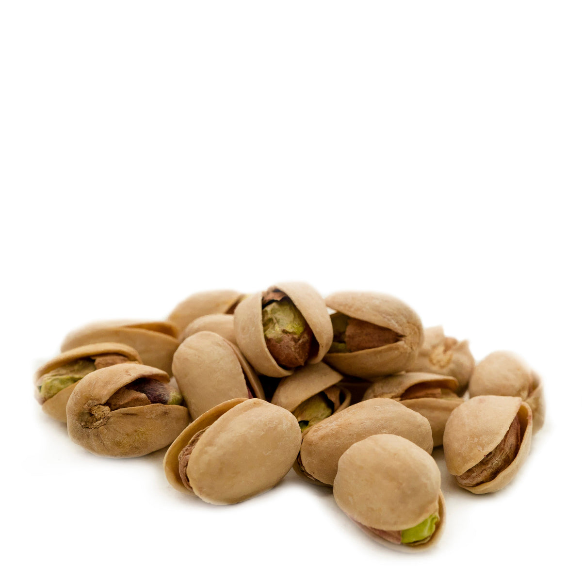 Dry roasted pistachios in a heap, light sea salt specks on shells