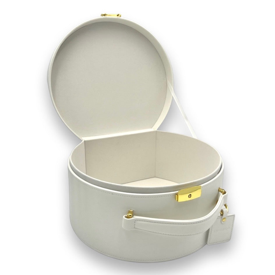 Cream round keepsake box open with beige interior and gold-tone front clasp