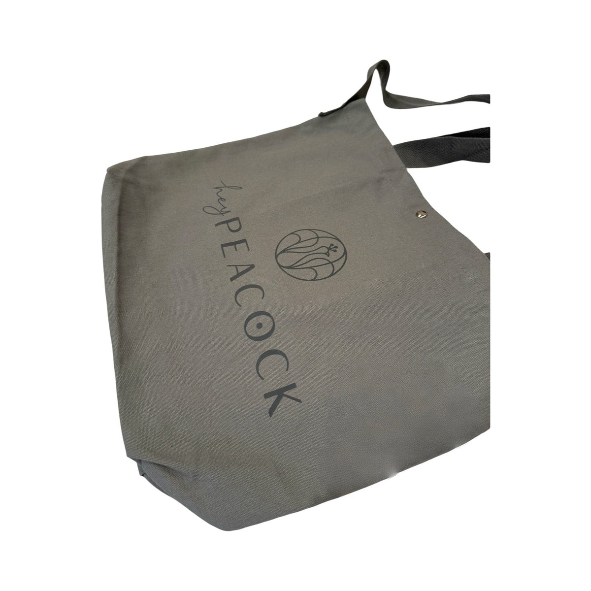 Gray canvas tote bag with peacock logo and vertical graphic text on side