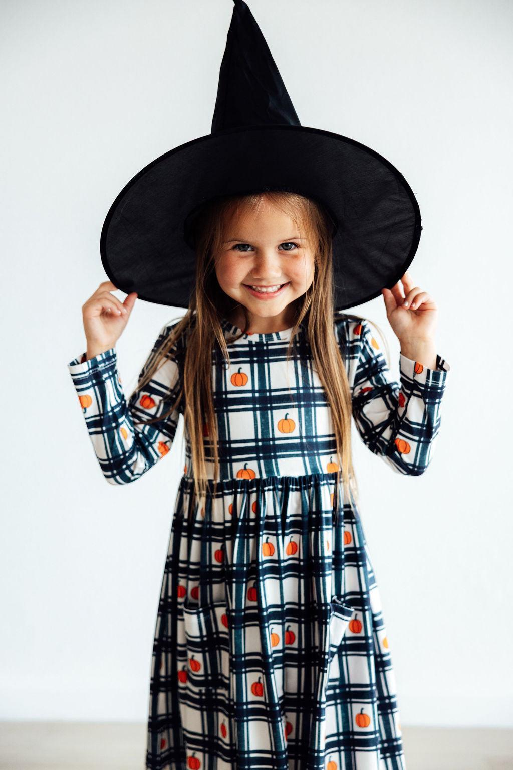 Long-sleeve plaid twirl dress with pumpkin motif print and gathered skirt, front pocket
