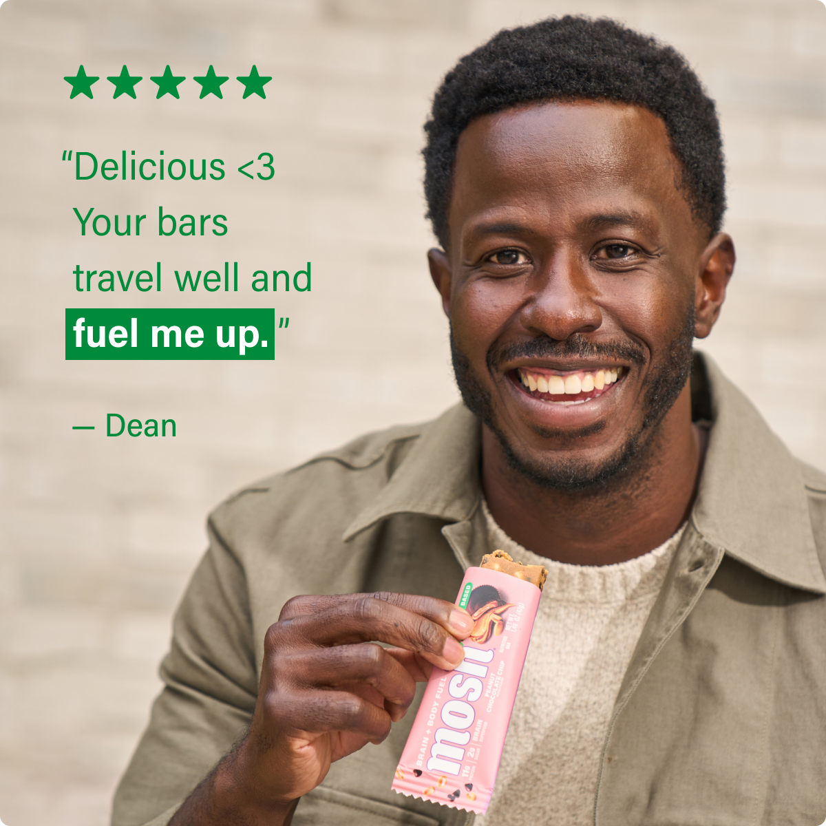 Pink plant-based snack bar held by hand with testimonial text and stars