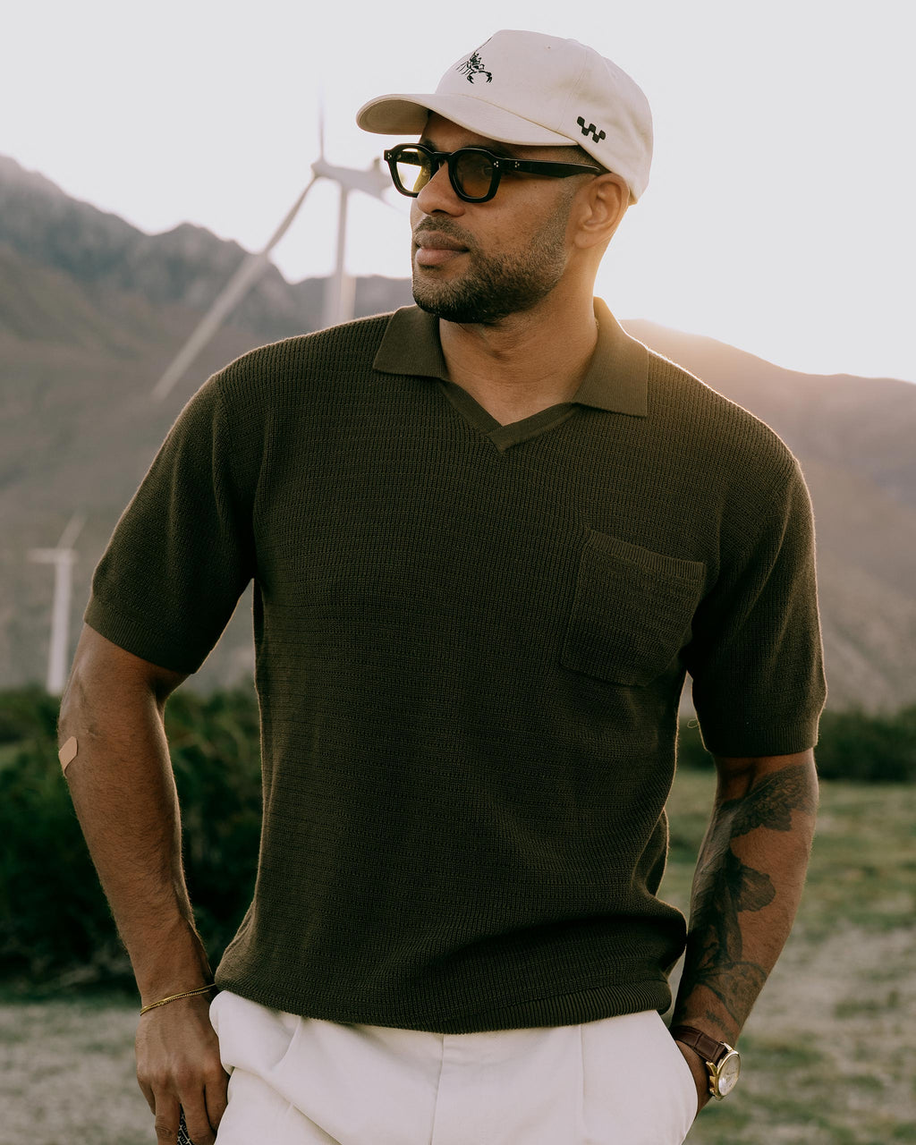 Men's dark-brown knit golf polo with collared neckline and chest pocket, short sleeves.