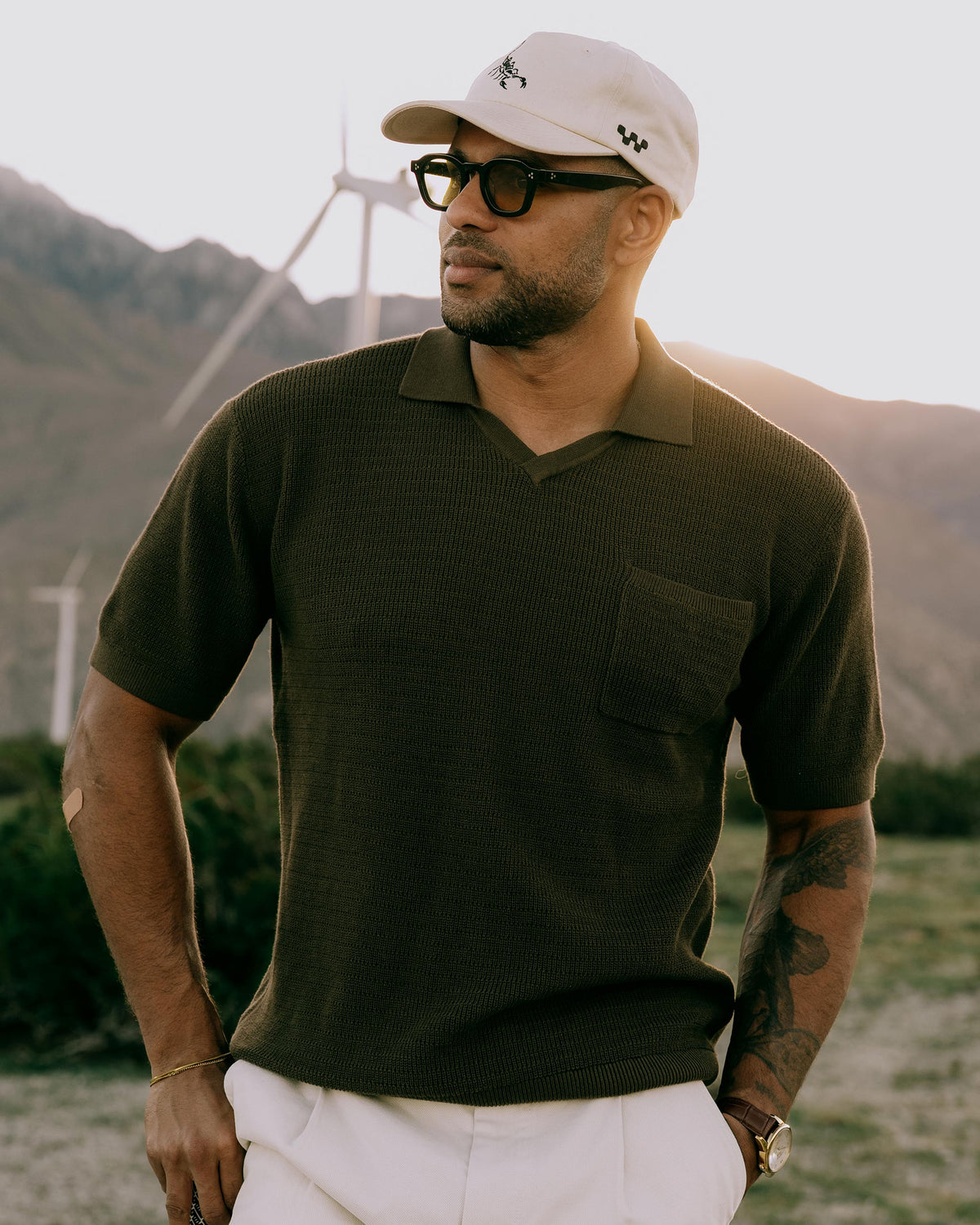 Men's dark-brown knit golf polo with collared neckline and chest pocket, short sleeves.