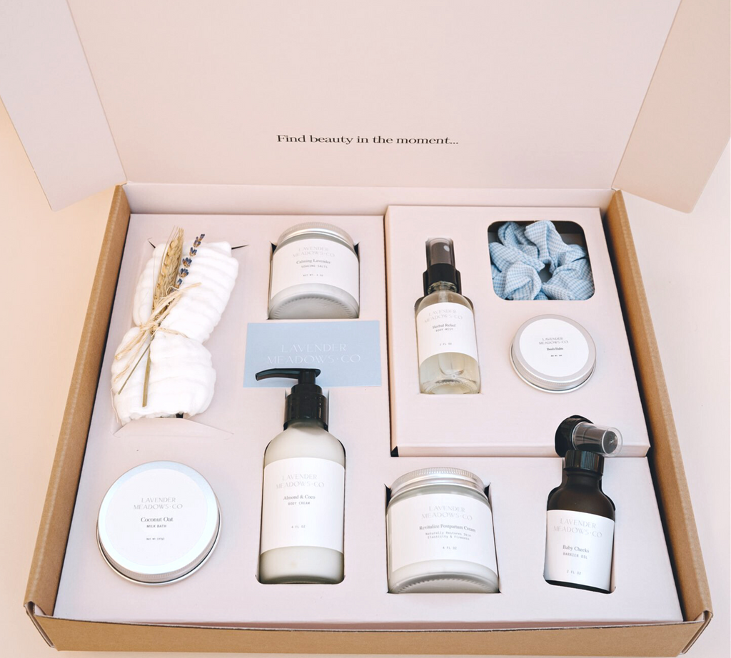 Postpartum care package deluxe set in open box with body mist, creams, balm, and salts