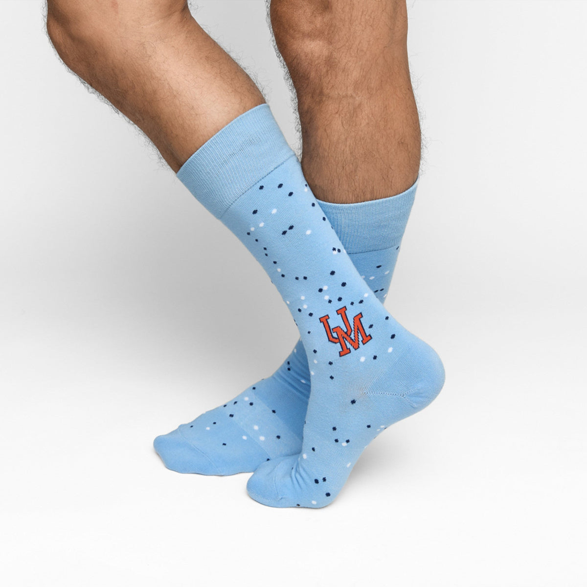 Light blue crew socks with small dotted pattern and red embroidered lettering
