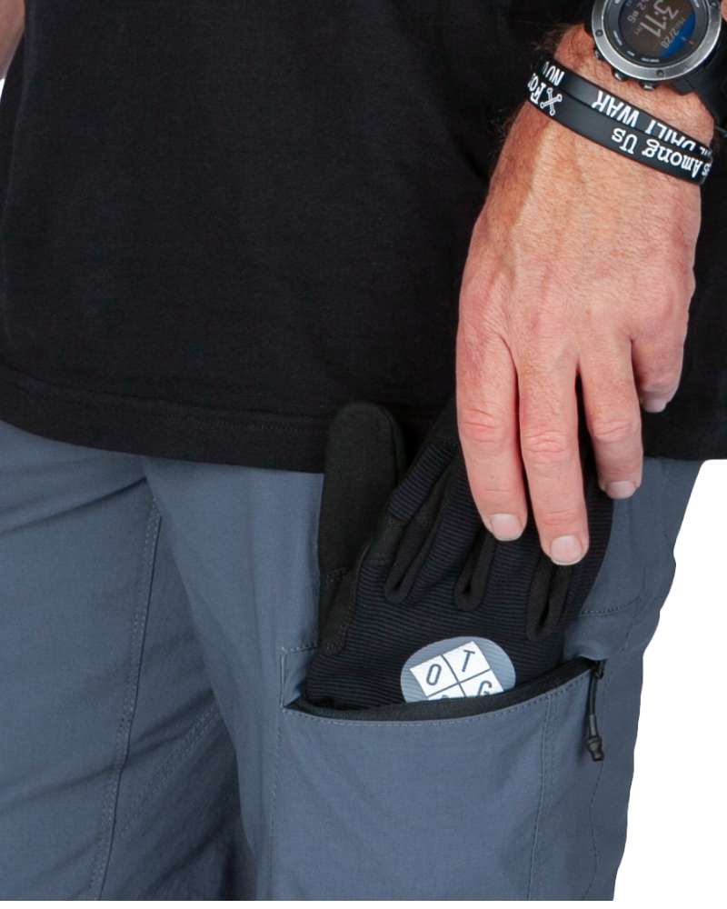 Gray-blue cargo pocket with black inner pouch and hand pulling it open