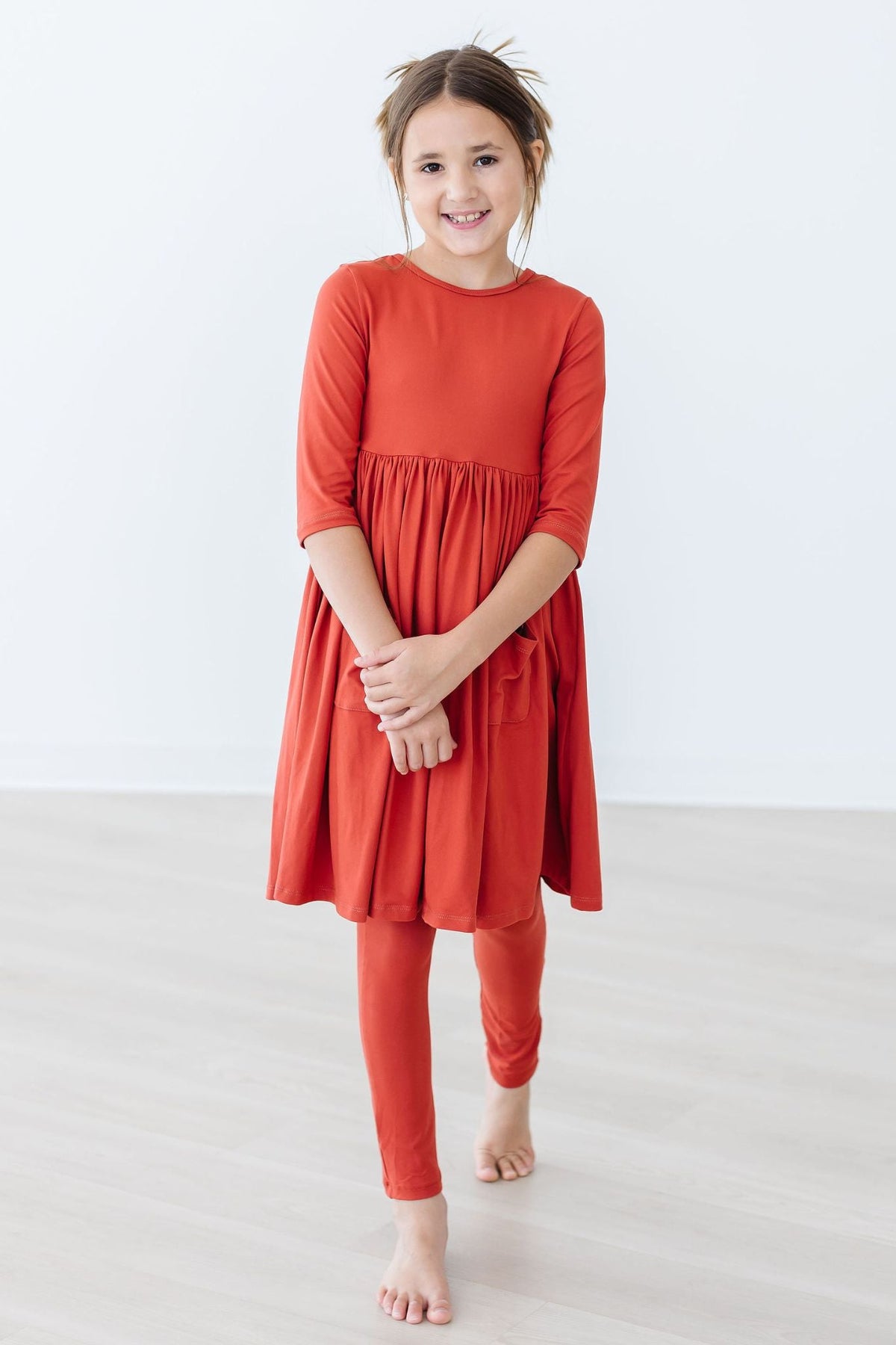 Coral red leggings on model, full length with elastic waistband