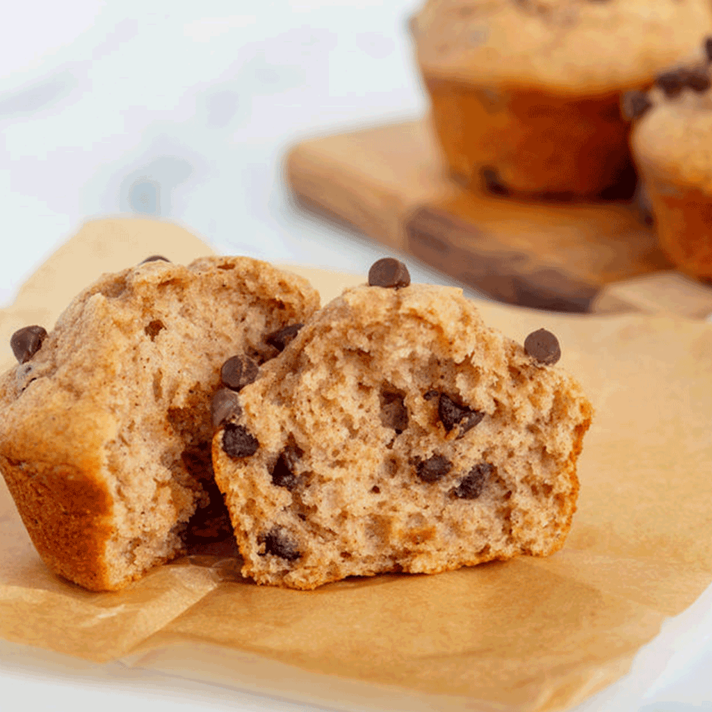 Pumpkin chocolate chip muffins on parchment with chocolate chips visible