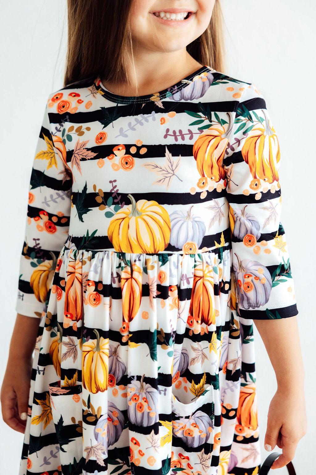 Girls' pumpkin print twirl dress with 3/4 sleeves and striped tiered skirt