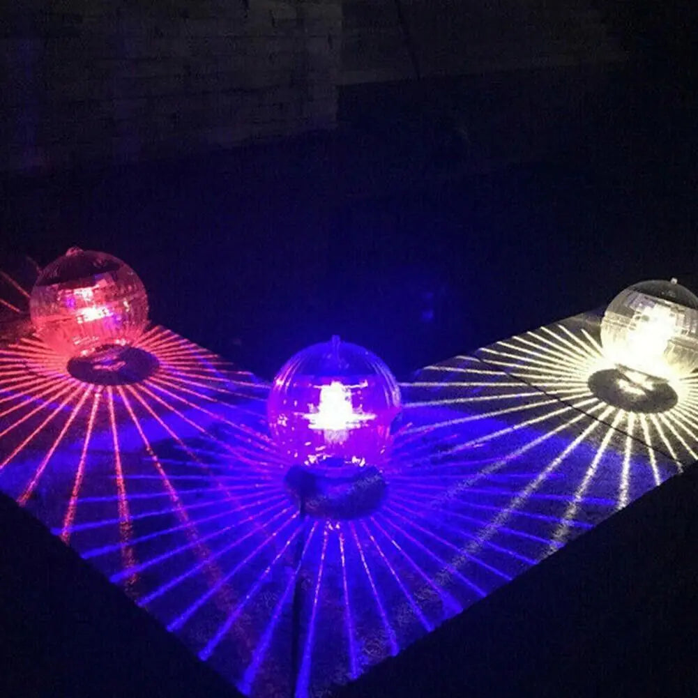 Solar LED floating dome lights casting red, blue, and white starburst beams