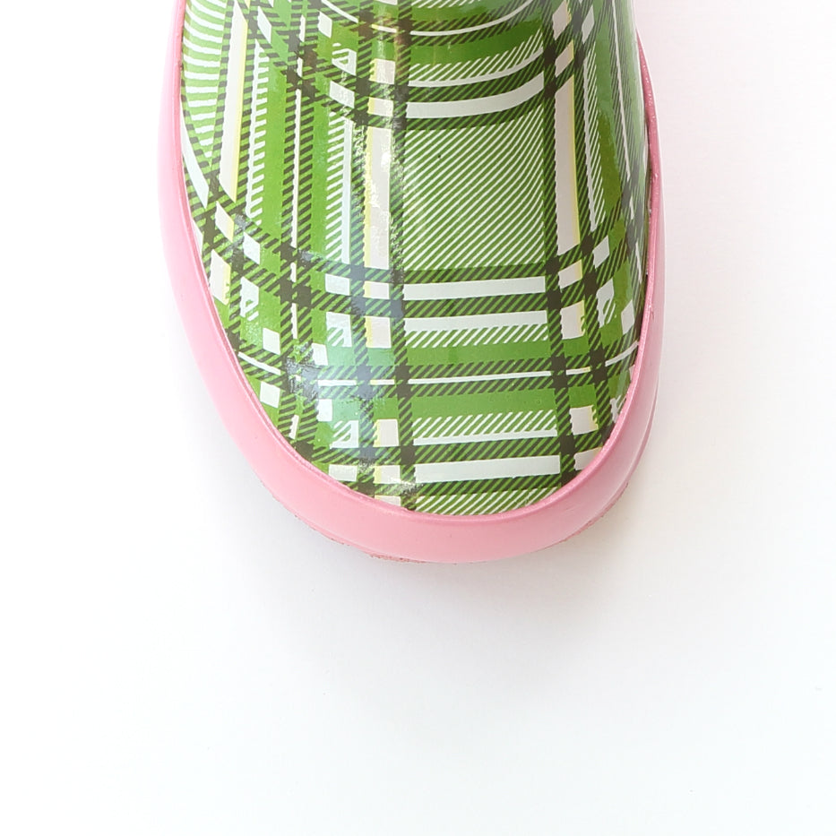 Close-up of green plaid rain boot with pink toe bumper and rubber sole