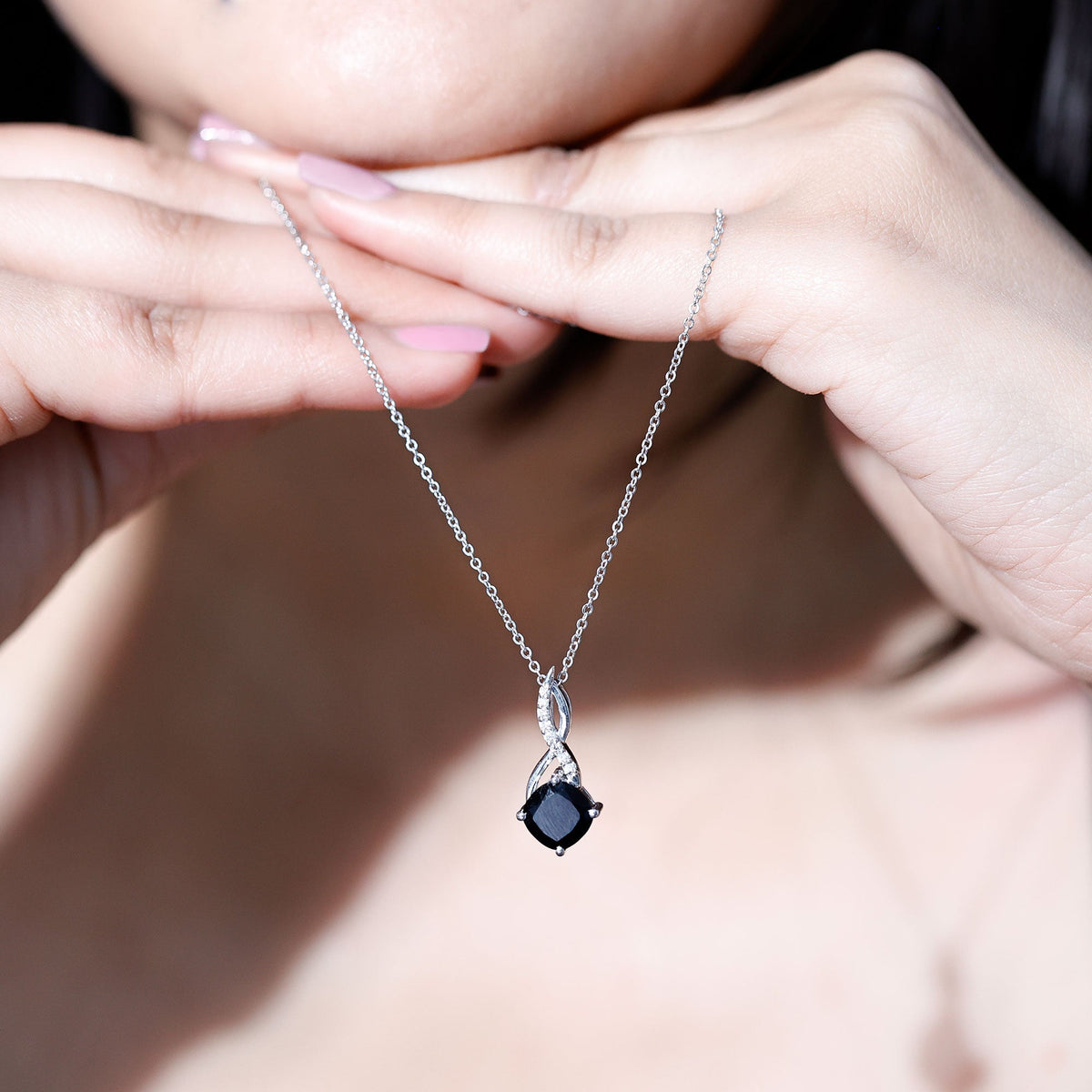 Cushion-cut black diamond infinity pendant necklace on a silver-tone chain close-up