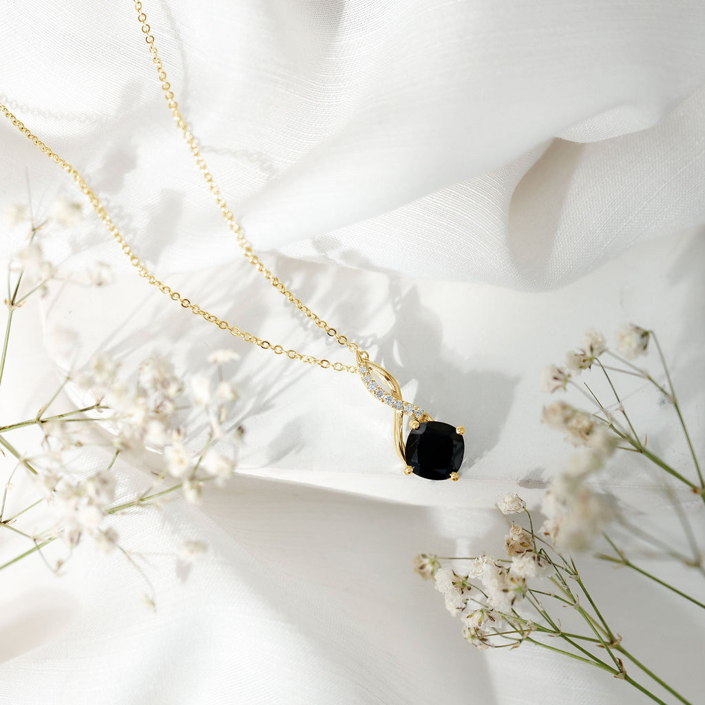 Gold infinity necklace with black cushion pendant