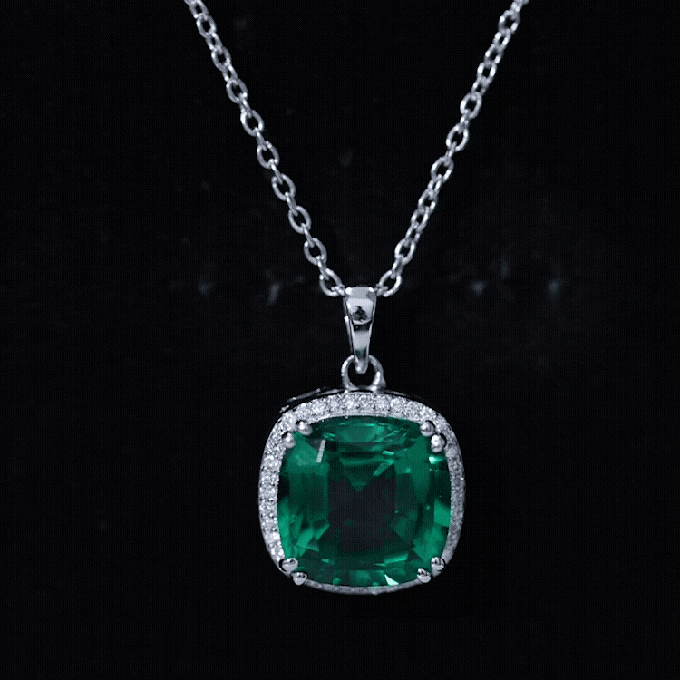 Silver-tone cushion emerald pendant with diamond halo on a chain, front view