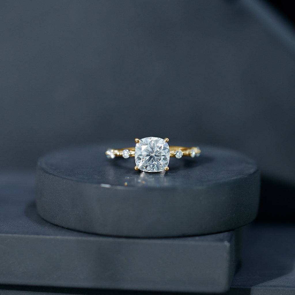 Yellow gold cushion-cut diamond solitaire ring with prong-set center and side stones
