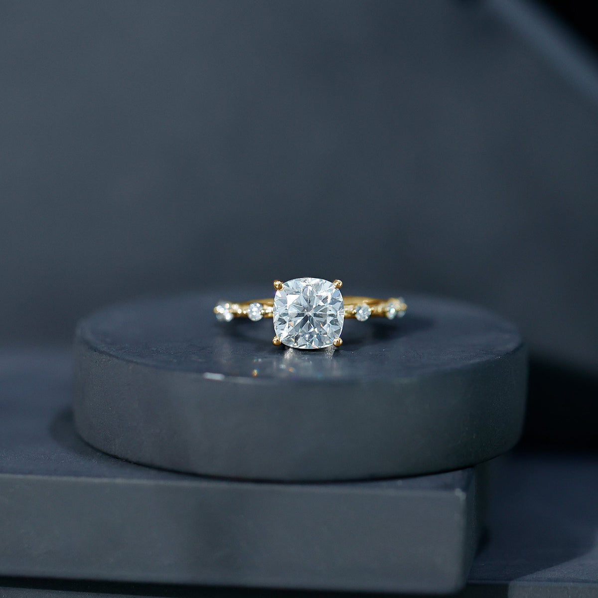 Yellow gold cushion-cut diamond solitaire ring with prong-set center and side stones