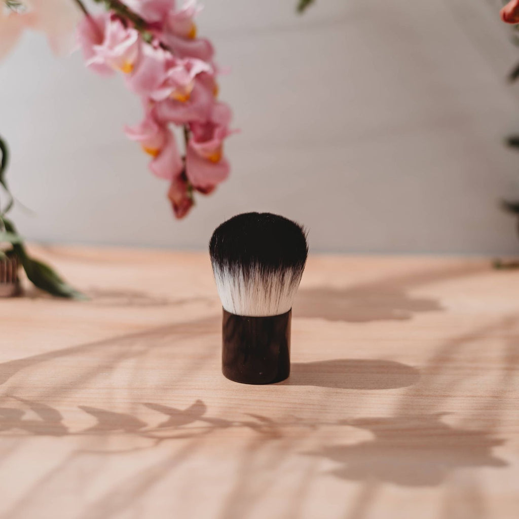 Self-tanning brush with soft bristles and a black handle
