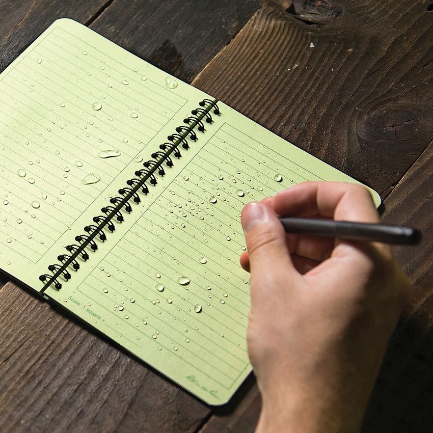 Waterproof notebook with green dotted pages and spiral binding, written with pen