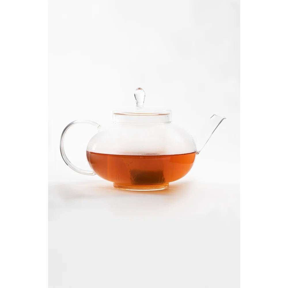 Borosilicate glass teapot with removable infuser, clear lid, handle, spout; amber tea inside