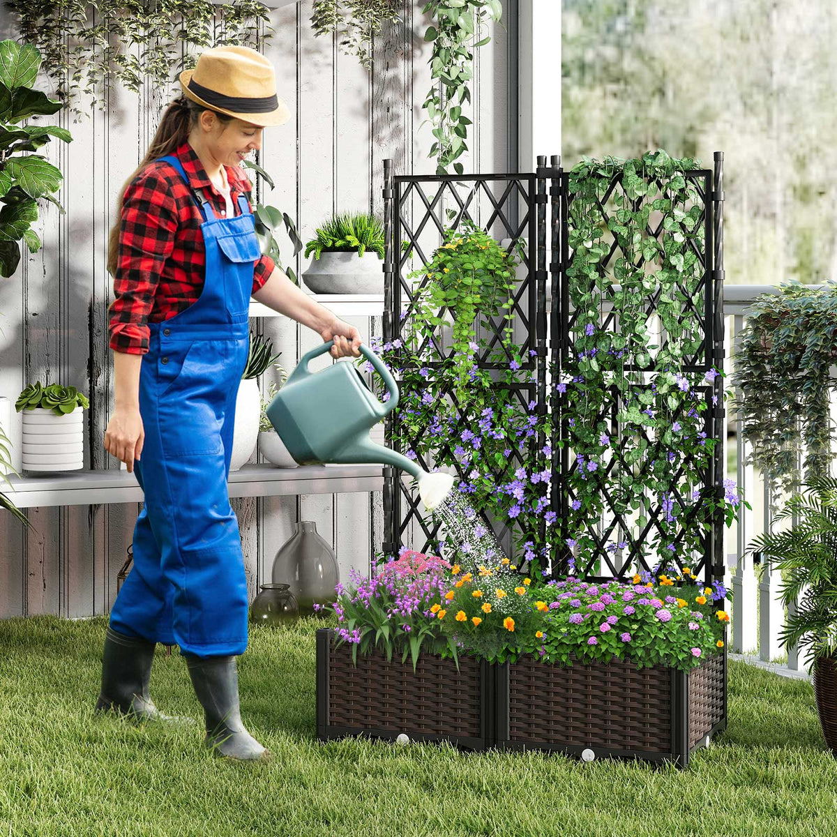 Black self-watering raised planter with diamond trellis and flowering plants