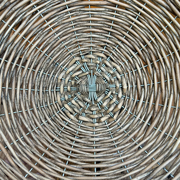 Close-up of woven willow lattice on the round riser basket, gray and pale strands