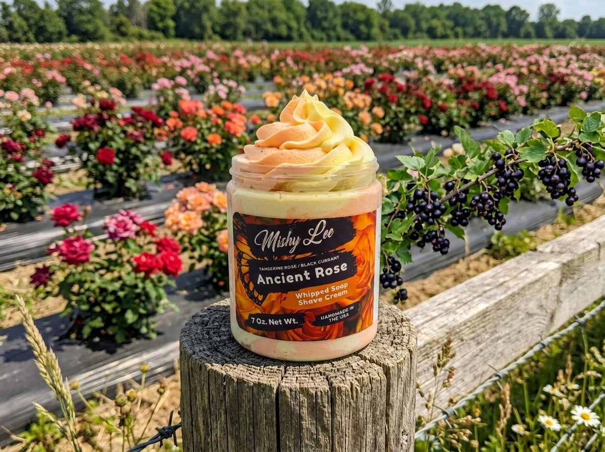 Whipped soap and shave cream jar with orange and yellow swirl topping on stone